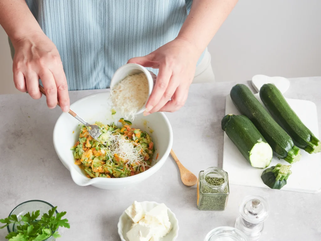 Zucchini noodle pesto bake with melted cheese and fresh basil on top