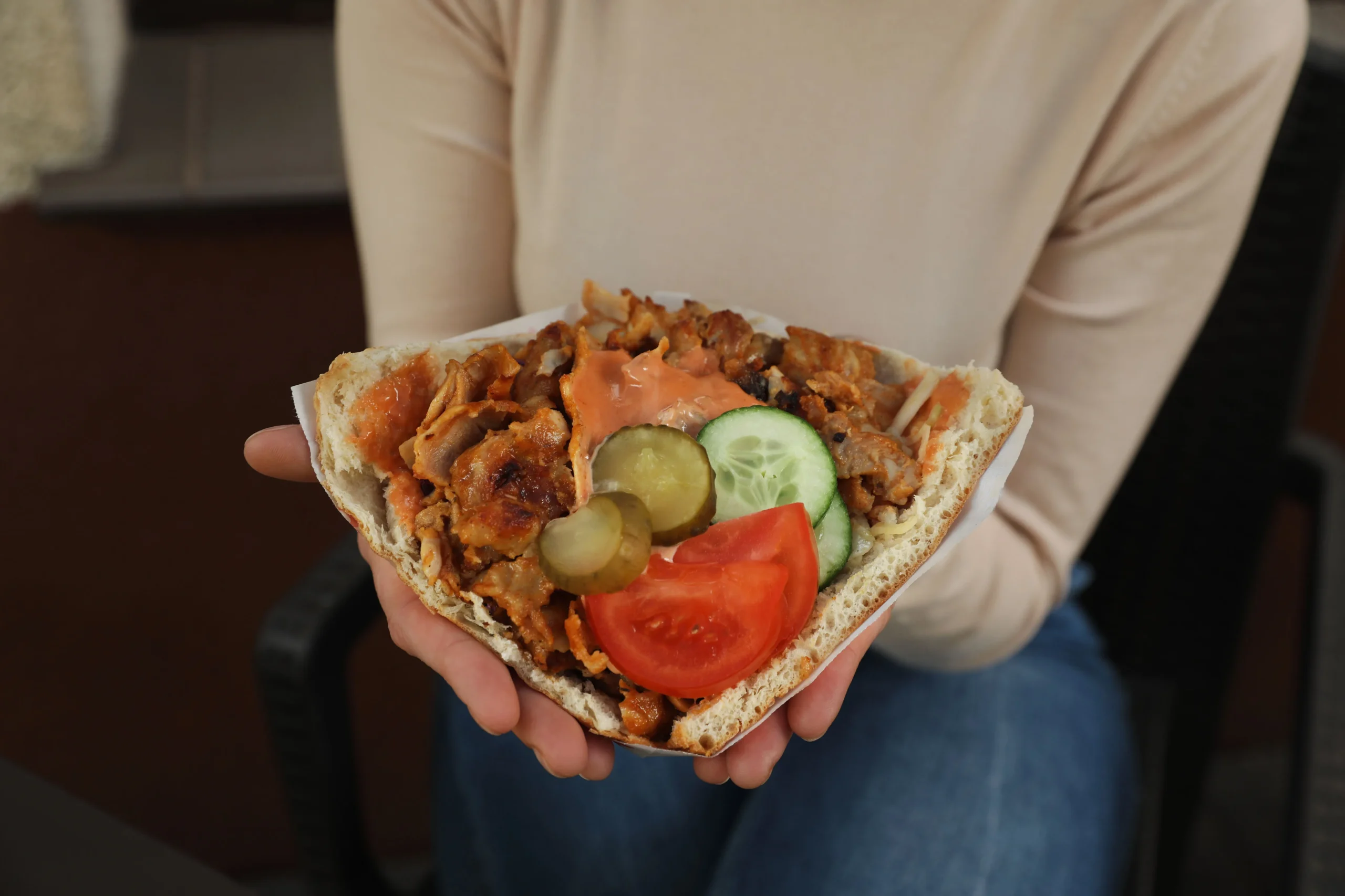 Close-up of homemade gyros with tender sliced gyro meat, fresh vegetables, and tzatziki sauce wrapped in warm pita bread