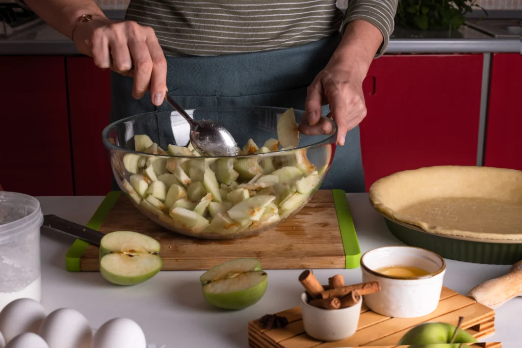 Homemade apple pie filling with fresh apples, cinnamon, and spices in a saucepan