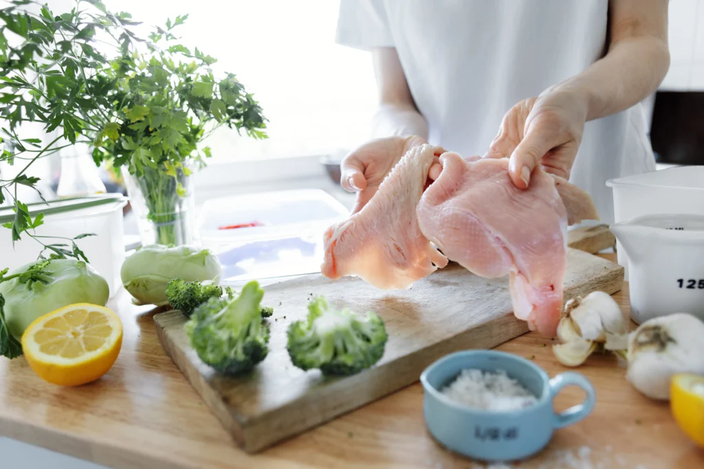 Almond chicken glazed with honey sauce, garnished with toasted almonds and fresh herbs on a white plate.