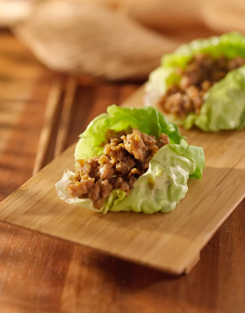 Asian chicken lettuce wraps filled with ground chicken, vegetables, and hoisin sauce served in crisp butter lettuce cups.