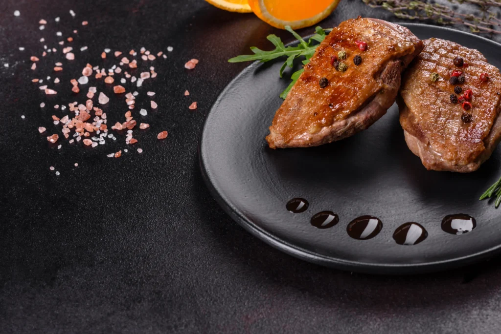 Honey garlic glazed duck breast with crispy skin and sticky sauce served on a plate