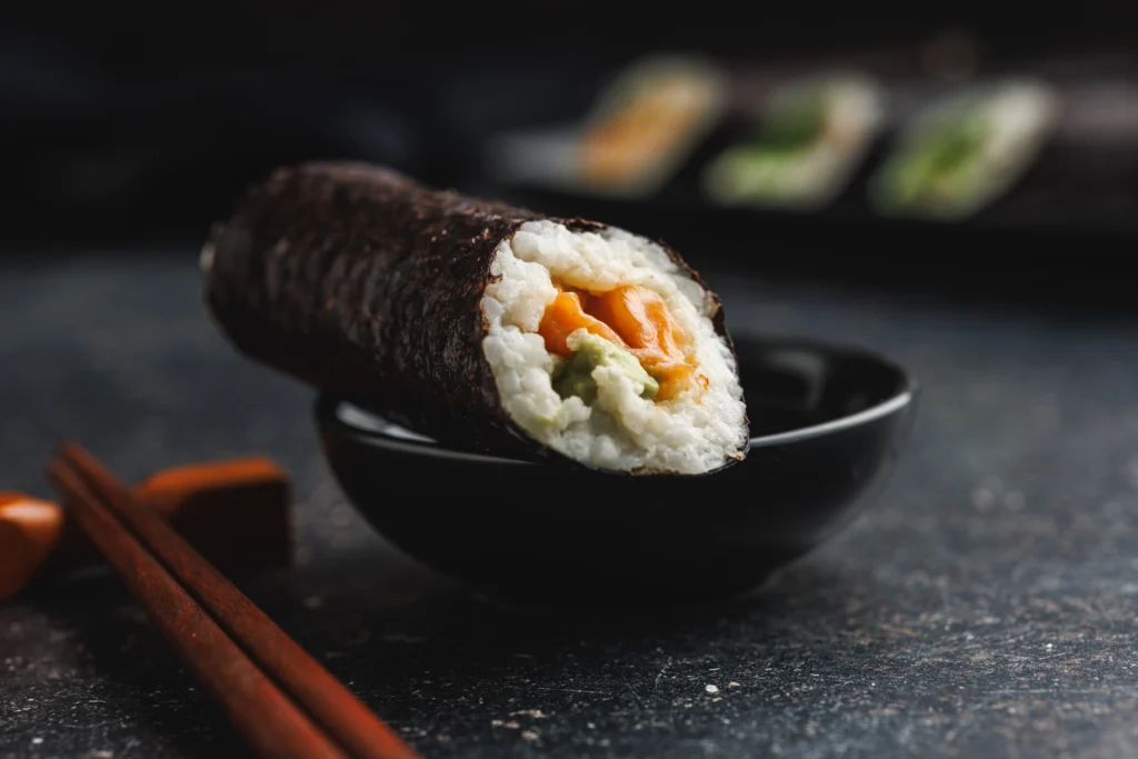 Keto-friendly rice sushi rolls made with cauliflower rice, avocado, cucumber, and nori, served fresh as a healthy low-carb sushi alternative.