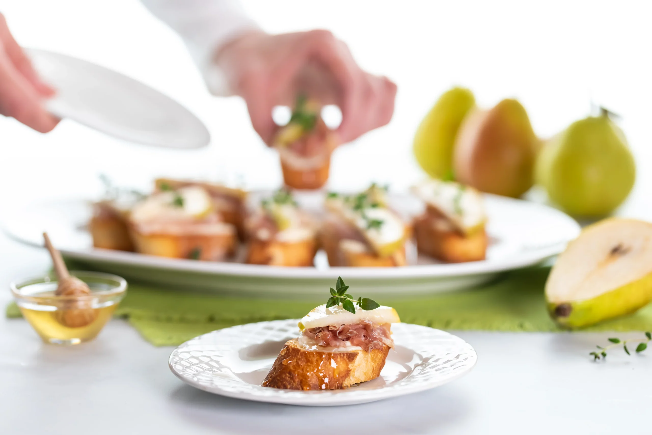 Golden Goat Cheese & Honey Crostini topped with flaky sea salt and fresh thyme on toasted baguette slices.