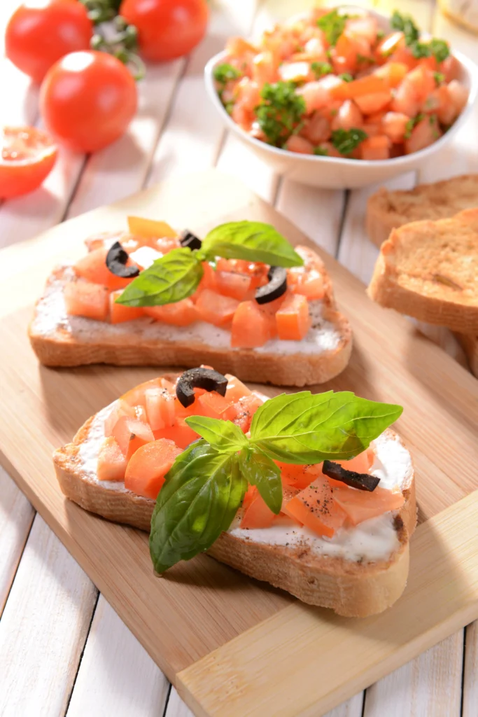 Smoked salmon crostini topped with fresh dill and capers on a bed of herb-infused cream cheese and toasted baguette slices.