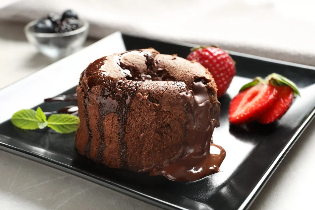 Molten chocolate lava cake for two with warm gooey chocolate center on dessert plate