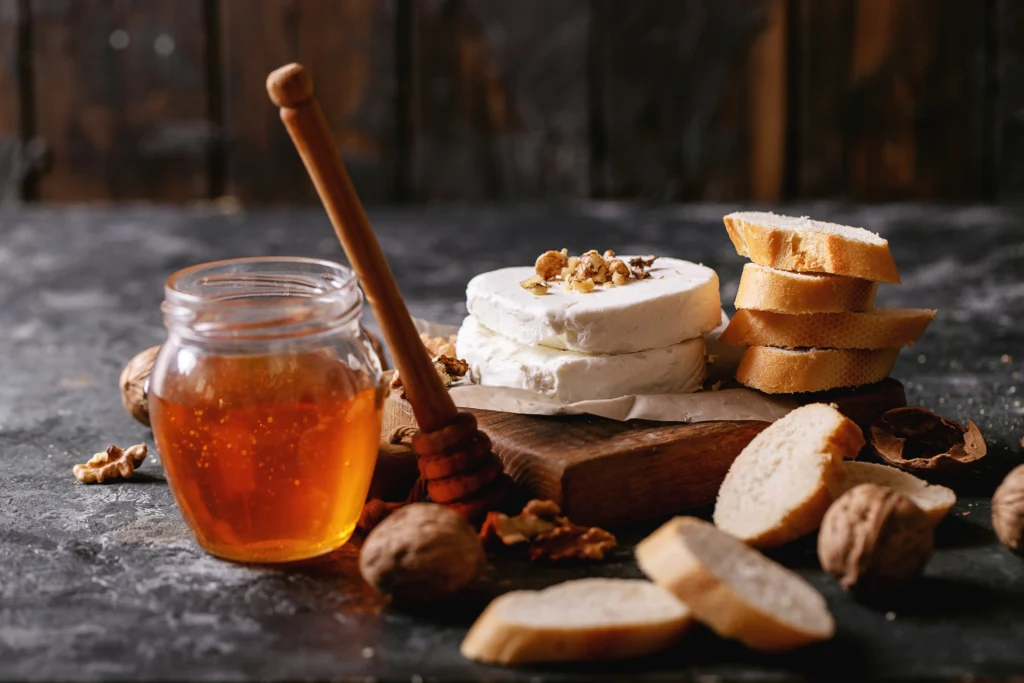 Golden Goat Cheese & Honey Crostini topped with flaky sea salt and fresh thyme on toasted baguette slices.