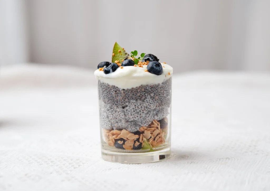 Overnight Oat Chia Parfait layered with Greek yogurt, fresh berries, chia seeds, and granola in a glass jar.