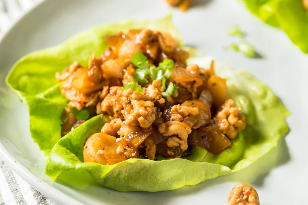 Asian chicken lettuce wraps filled with ground chicken, vegetables, and hoisin sauce served in crisp butter lettuce cups.