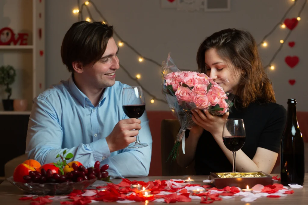 A romantic Valentine’s Day berry mocktail in a heart-shaped glass, garnished with fresh strawberries, raspberries, and mint leaves on a festive pink table setting.