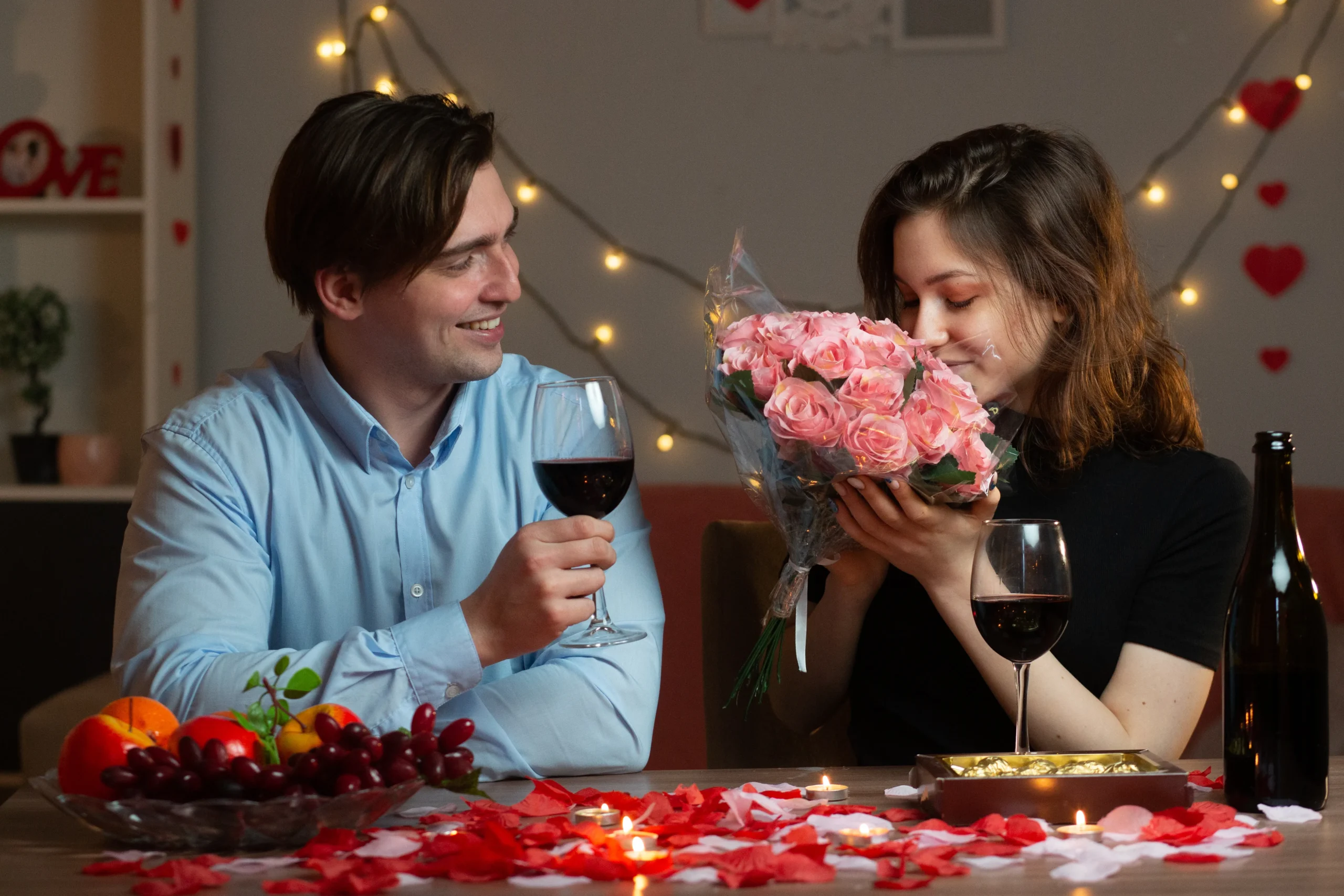 A romantic Valentine’s Day berry mocktail in a heart-shaped glass, garnished with fresh strawberries, raspberries, and mint leaves on a festive pink table setting.