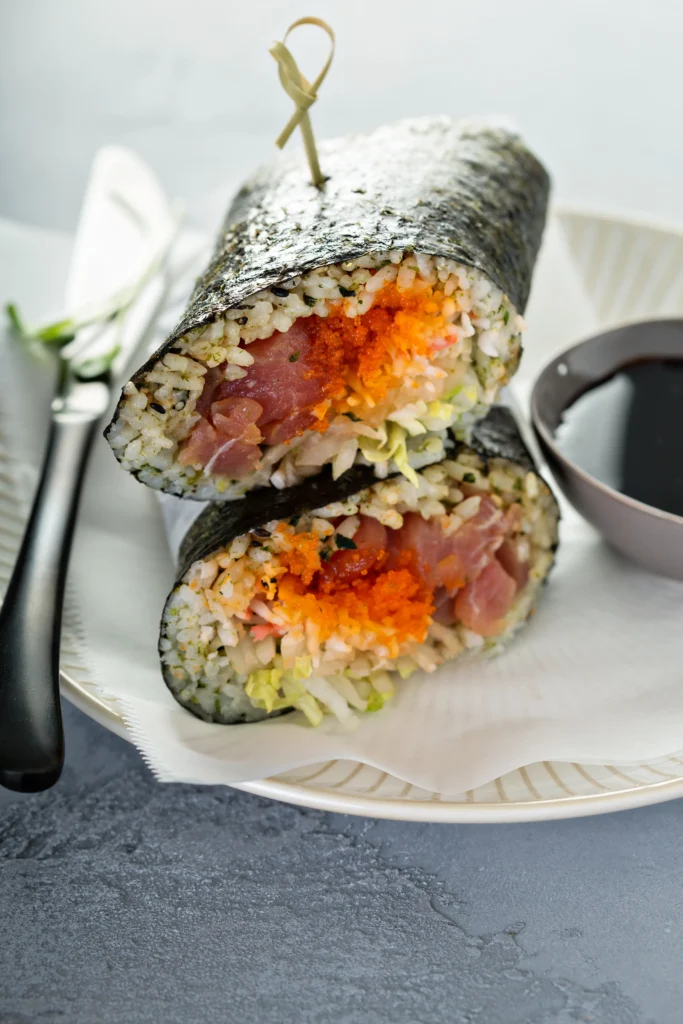 Keto-friendly rice sushi rolls made with cauliflower rice, avocado, cucumber, and nori, served fresh as a healthy low-carb sushi alternative.