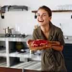 Juicy steak with peppercorn cream sauce sliced on a plate with creamy sauce and fresh cracked pepper on top