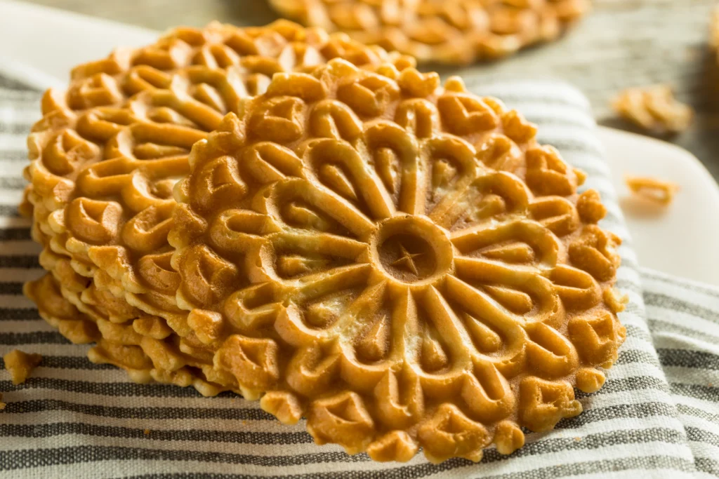 Homemade pizzelle cookies on a plate made with a foolproof pizzelle recipe for beginners