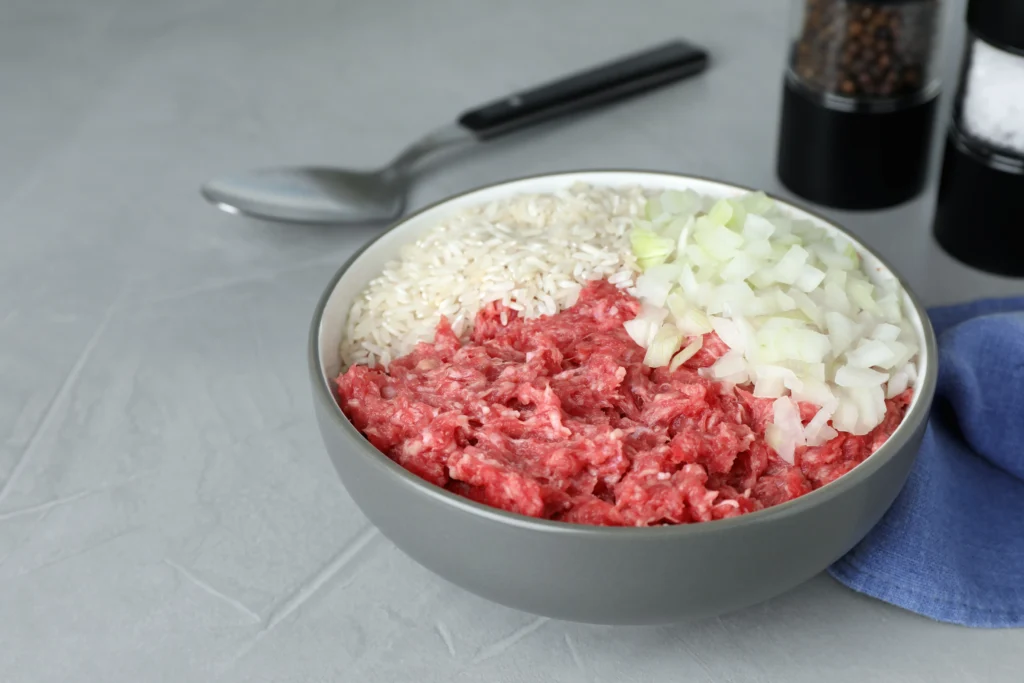 Ground beef and rice recipe served in a bowl with vegetables and herbs, a hearty homemade family dinner