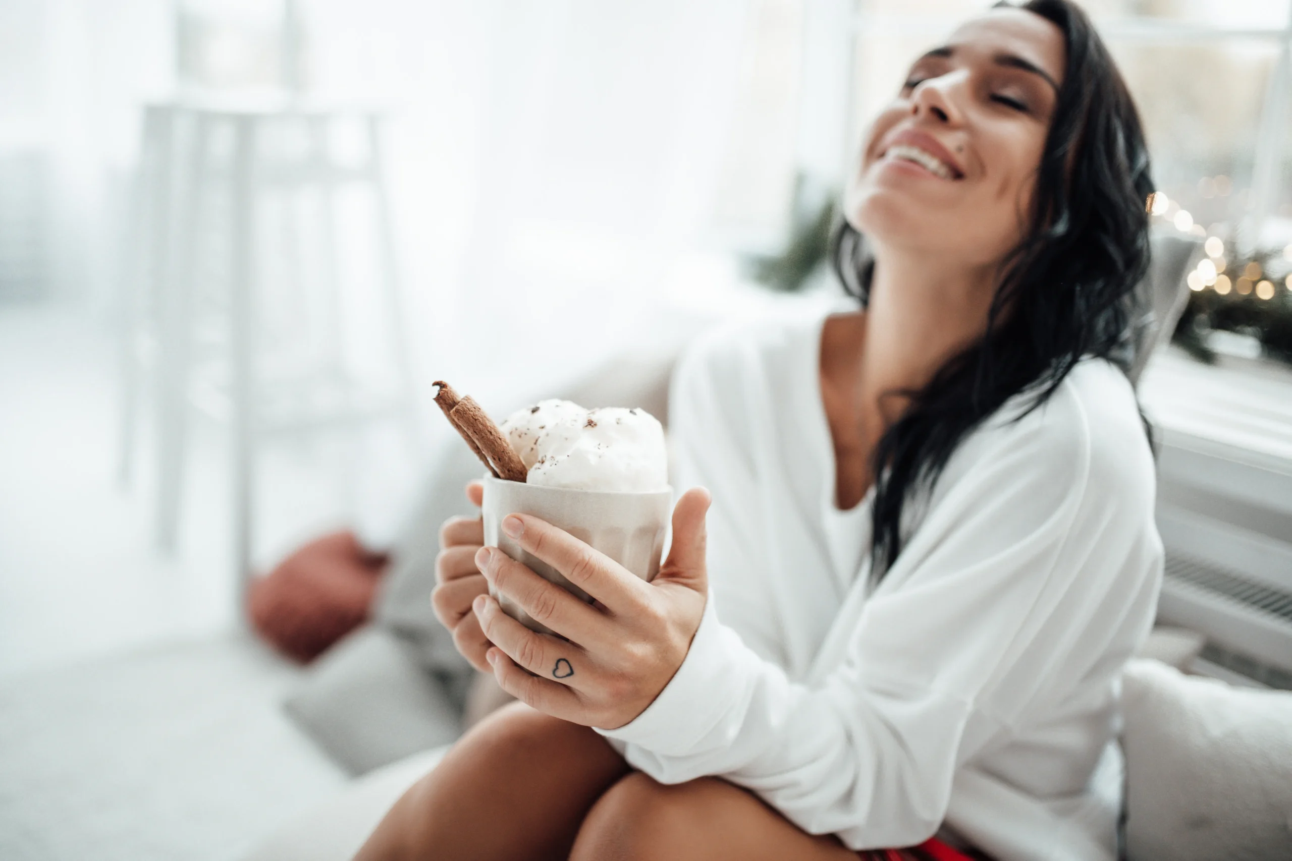 Festive Coquito in a glass with cinnamon stick and grated nutmeg, traditional Puerto Rican Christmas drink on a holiday table.