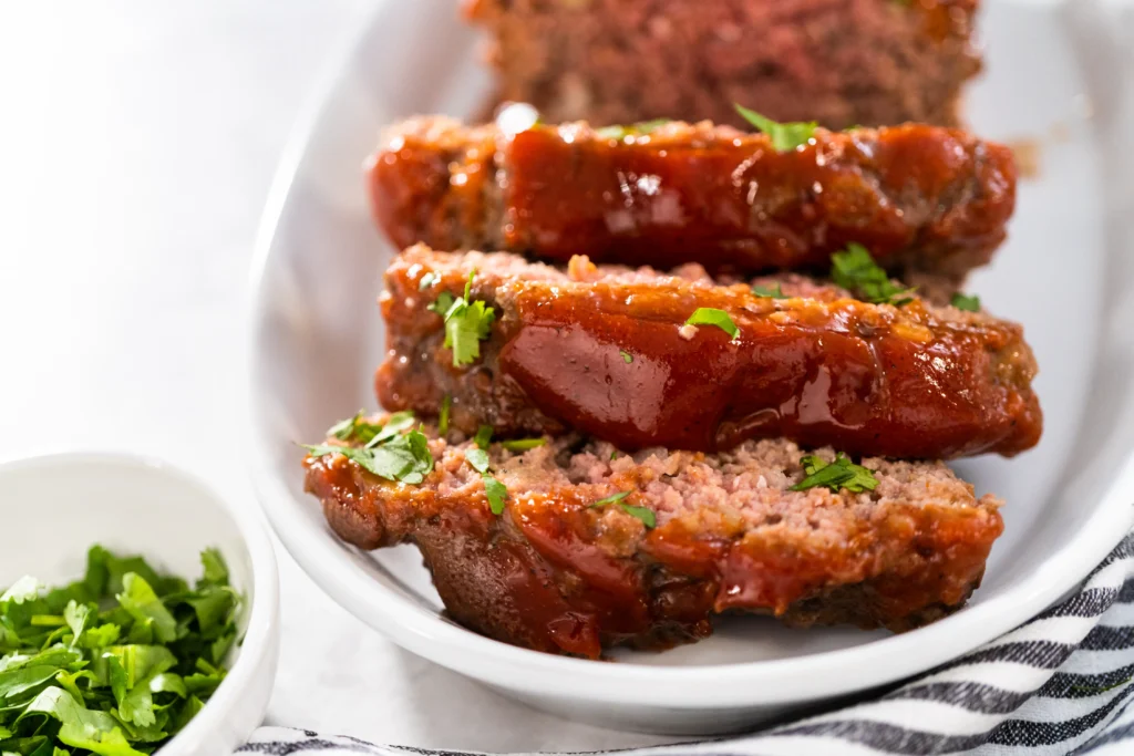 Easy homemade Cracker Barrel-style meatloaf on a plate with mashed potatoes and gravy
