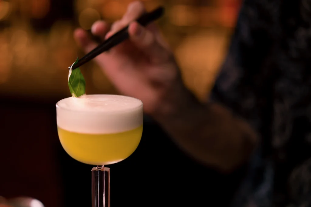 Perfect Pisco Sour cocktail in a chilled glass topped with creamy foam and fresh lime garnish