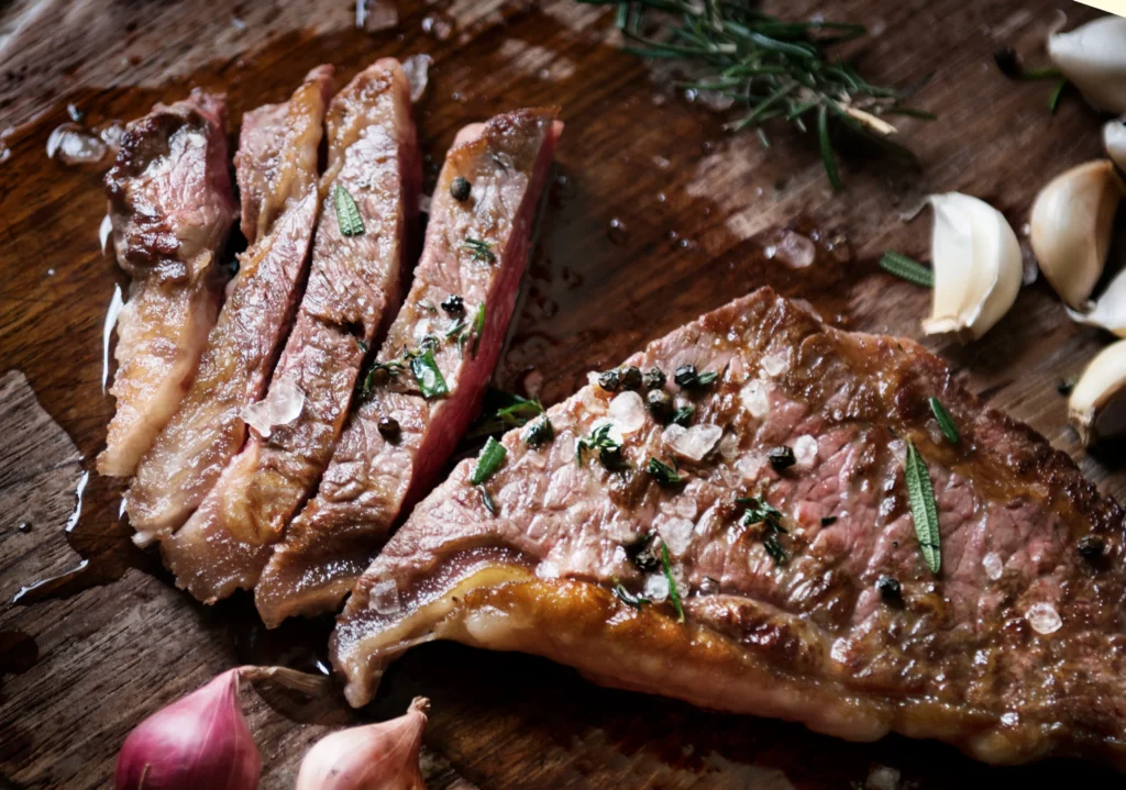 Quick London Broil recipe with garlic and herbs served on a wooden cutting board, juicy and perfectly cooked