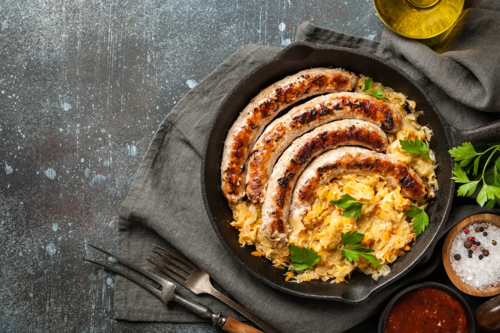 German-style bratwurst served with sauerkraut on a rustic plate, traditional sausage recipe with mustard and herbs
