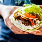 Delicious Asian-style lettuce wraps filled with savory chicken, vegetables, and hoisin sauce on a white plate