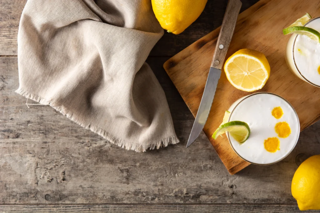 Perfect Pisco Sour cocktail in a chilled glass topped with creamy foam and fresh lime garnish