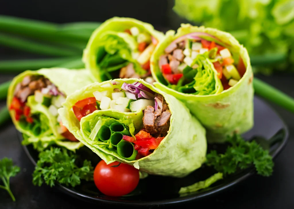 Fresh vegetarian lettuce wraps filled with colorful vegetables and tofu, served in crisp green lettuce leaves