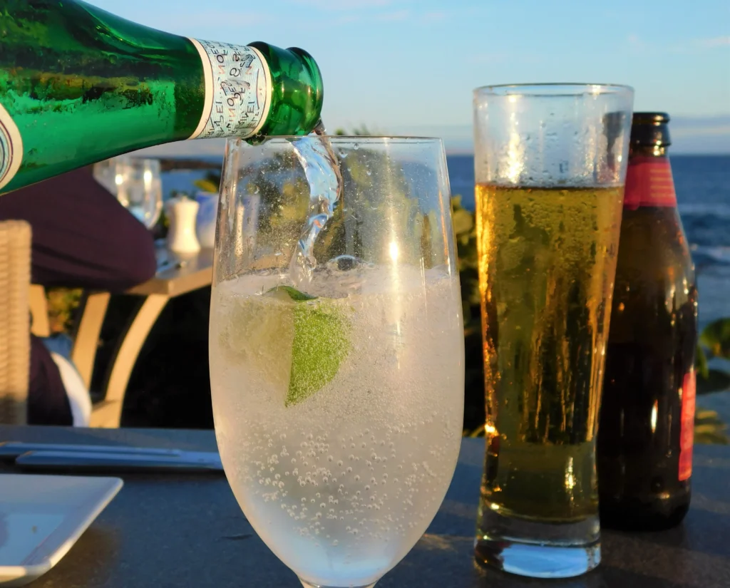 Refreshing Hugo Spritz cocktail with prosecco, elderflower syrup, lime slices, mint leaves, and ice in a wine glass