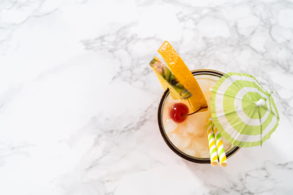 A glass of sweet, fruity Painkiller cocktail with tropical fruit garnish, ready to serve