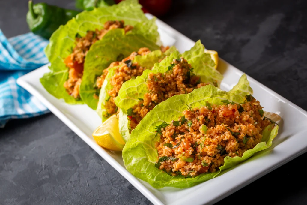 Delicious Asian-style lettuce wraps filled with savory chicken, vegetables, and hoisin sauce on a white plate