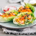 Fresh vegetarian lettuce wraps filled with colorful vegetables and tofu, served in crisp green lettuce leaves