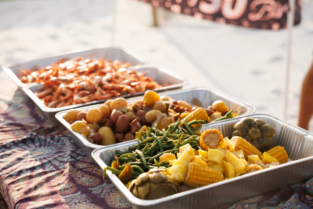 Cajun seafood boil with shrimp, crab legs, corn on the cob, potatoes, and spicy seasoning served on a rustic table
