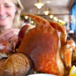 Cajun seafood boil with shrimp, crab legs, corn on the cob, potatoes, and spicy seasoning served on a rustic table