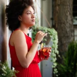 Colorful holiday rum punch cocktail with citrus slices, cranberries, and ice in a festive glass