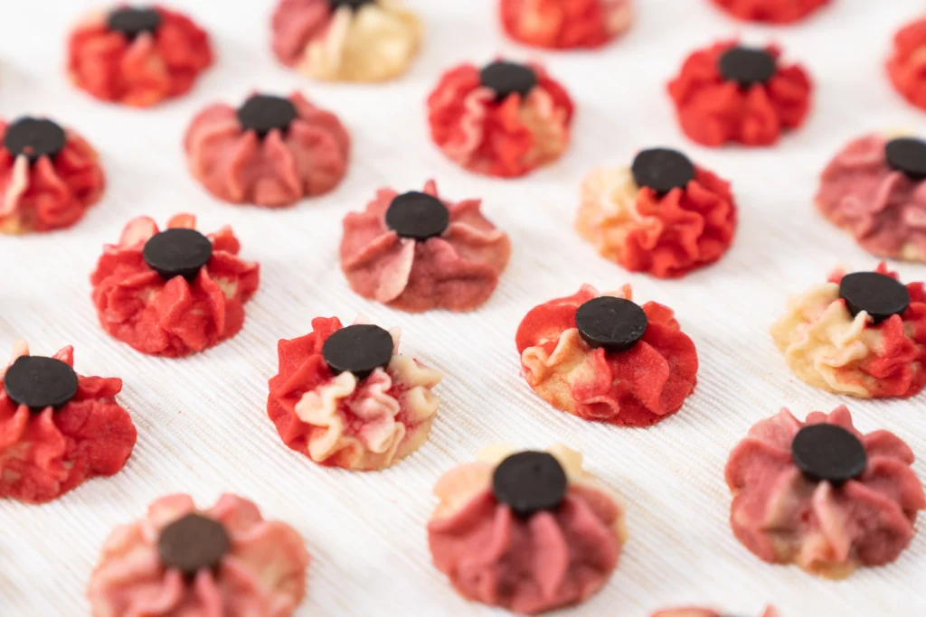 Buttery homemade spritz cookies in festive shapes on a baking tray, freshly baked and golden edges