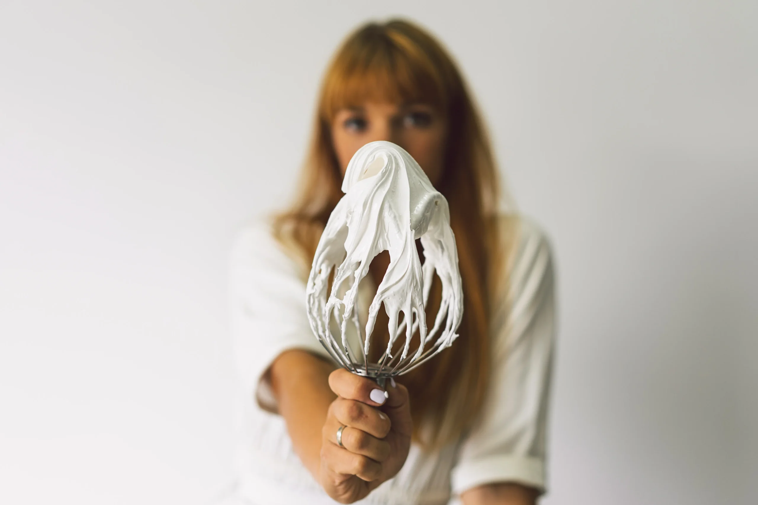 Whipped meringue with glossy stiff peaks in a mixing bowl showing perfect texture for a foolproof meringue recipe.