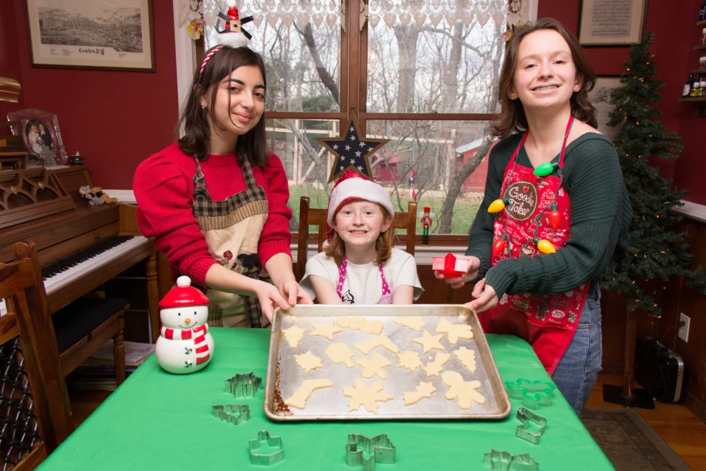 Buttery homemade spritz cookies in festive shapes on a baking tray, freshly baked and golden edges