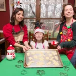 Buttery homemade spritz cookies in festive shapes on a baking tray, freshly baked and golden edges