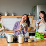 Creamy homemade Caesar dressing in a bowl with fresh salad ingredients on a wooden table