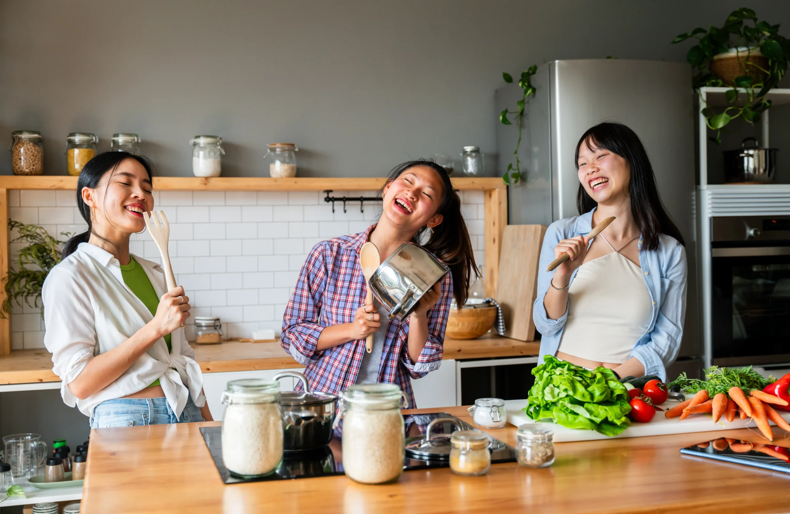 Creamy homemade Caesar dressing in a bowl with fresh salad ingredients on a wooden table