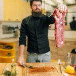 Sliced tender flank steak served on a cutting board with herbs and juices