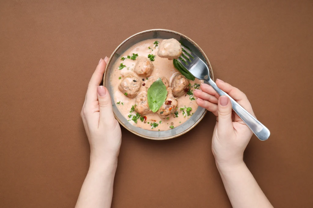 Homemade chicken gravy in a bowl served with rice, rich and creamy sauce with tender chicken pieces and fresh herbs