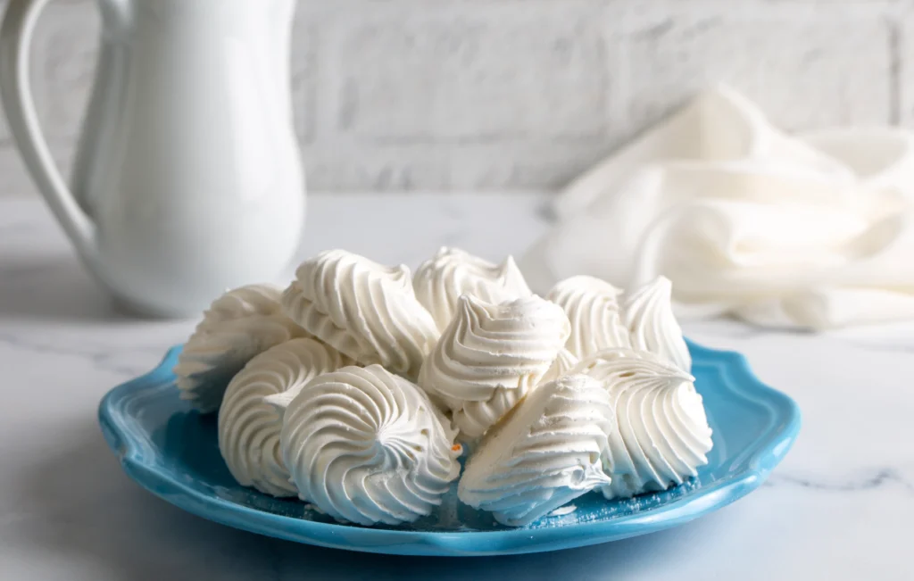 Whipped meringue with glossy stiff peaks in a mixing bowl showing perfect texture for a foolproof meringue recipe.
