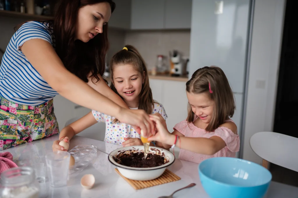 A fun dirt pudding dessert served in clear cups, layered with creamy chocolate pudding, crushed chocolate cookies, and gummy worms on top.