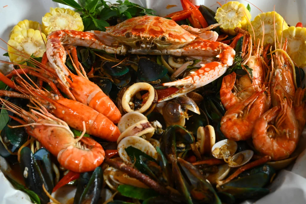 Cajun seafood boil with shrimp, crab legs, corn on the cob, potatoes, and spicy seasoning served on a rustic table