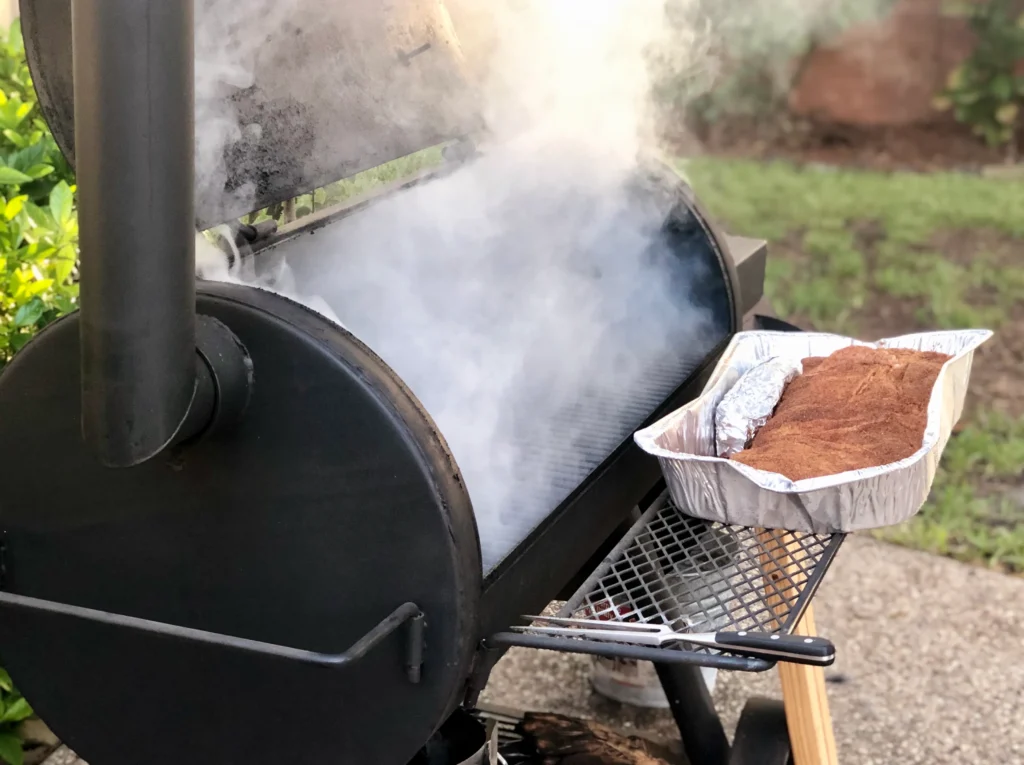 Smoked brisket sliced on a wooden board with a crispy bark and juicy interior, served at a BBQ party