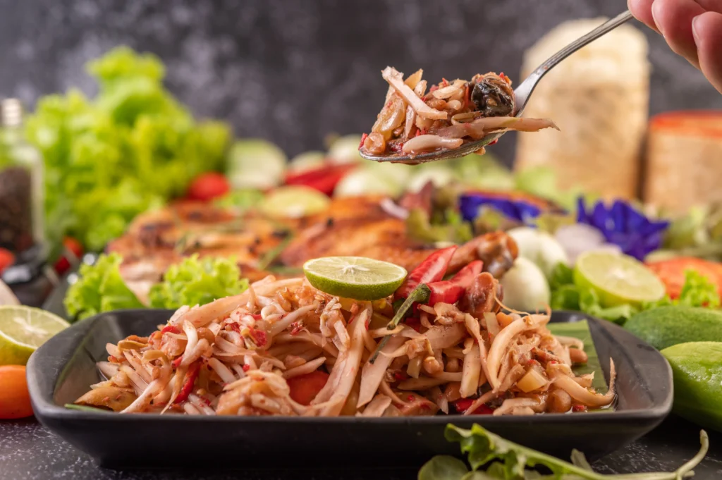Juicy shredded chicken in a bowl with herbs, showing a tender texture from an easy shredded chicken recipe.