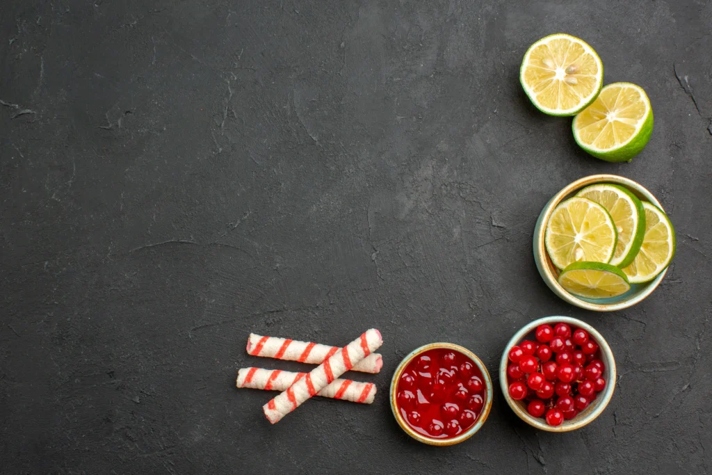Colorful holiday rum punch cocktail with citrus slices, cranberries, and ice in a festive glass