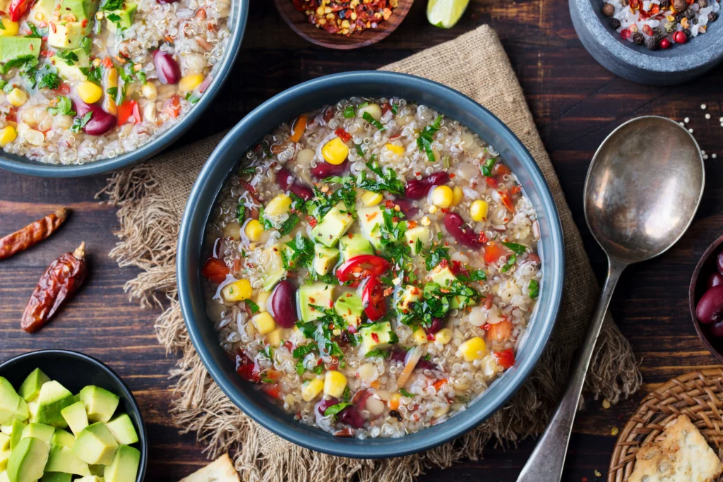 A variety of healthy crockpot meals including vegetable stew, chicken with herbs, and lentil soup served in bowls on a rustic kitchen table.