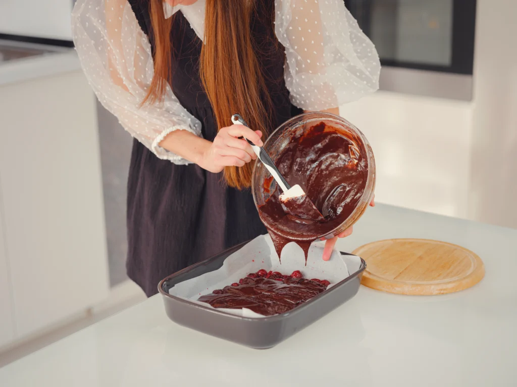Freshly baked Texas Sheet Cake topped with rich chocolate frosting and chopped pecans on a rustic kitchen table